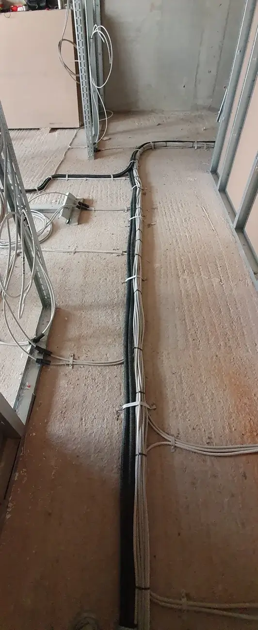 Verlegung von Installationsrohren auf dem Boden eines Wohnhausflurs